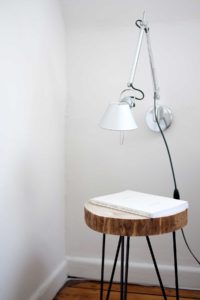 small round wooden table with a light above it